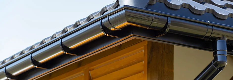 Schwarze Dachrinne an Holzhütte